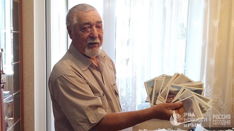 Николай Плясов демонстрирует открытки из своей коллекции